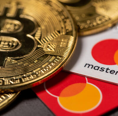 A bitcoin on top of Mastercard credit cards