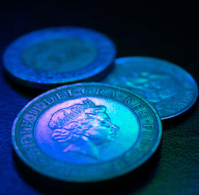 pound coin in blue light
